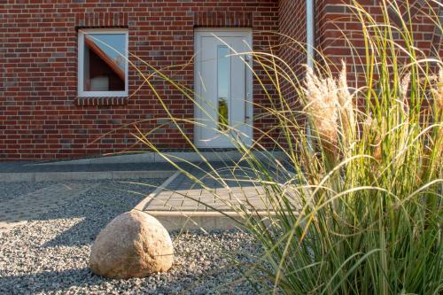 a building with a window and a rock in a yard at Ferienhaus Rüno I in Thesenvitz