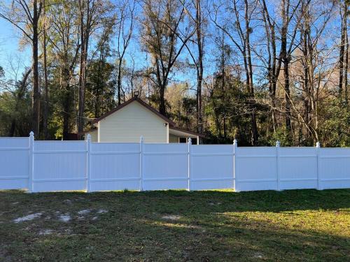 a white fence in front of a house at Amazing little house at Gnv in Gainesville