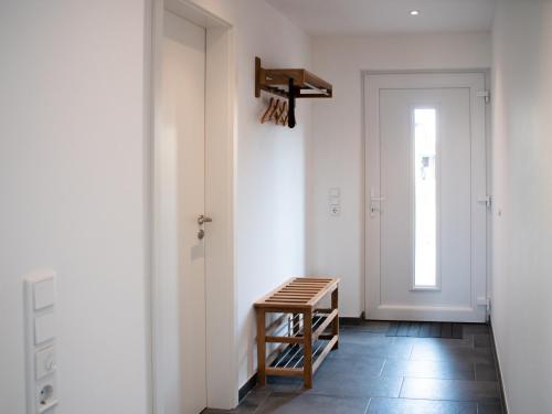 a hallway with a wooden stool next to a door at Ferienhaus Rüno I in Thesenvitz