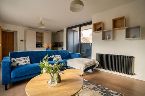 a living room with a blue couch and a table at The Penthouse in York