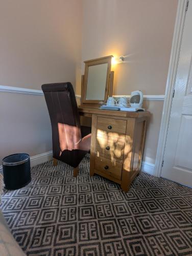 a room with a desk with a mirror and a chair at Willowbank House in Enniskillen