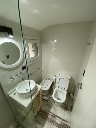 a bathroom with a toilet and a sink and a mirror at Casa Torre VLA in Villa La Angostura