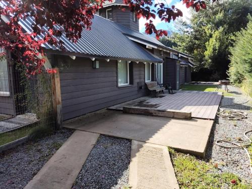 a house with a wooden porch with a bench on it at Casa Torre VLA in Villa La Angostura
