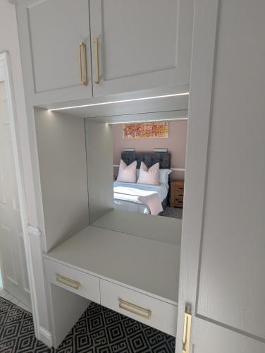 a bedroom with a bed and a white cabinet at Willowbank House in Enniskillen