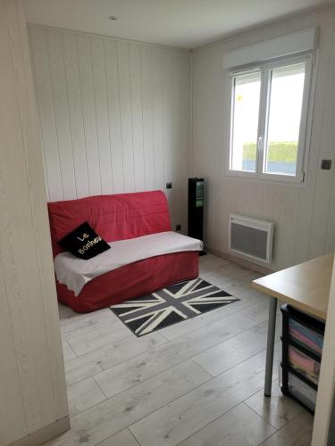 une chambre avec un lit rouge dans l'angle d'une pièce dans l'établissement Chez Pauline, à Clion