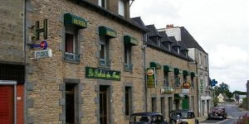 un bâtiment en briques avec des voitures garées devant lui dans l'établissement Relais du méne, à Collinée