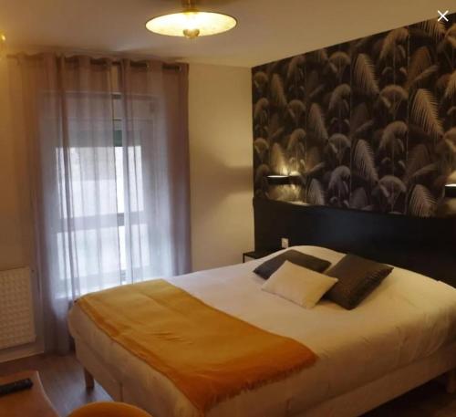 - une chambre avec un grand lit et un grand mur dans l'établissement Relais du méne, à Collinée