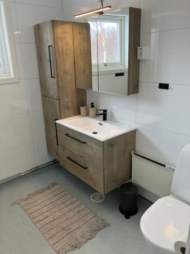 a bathroom with a sink and a mirror and a toilet at Røssøyhytta in Steigen