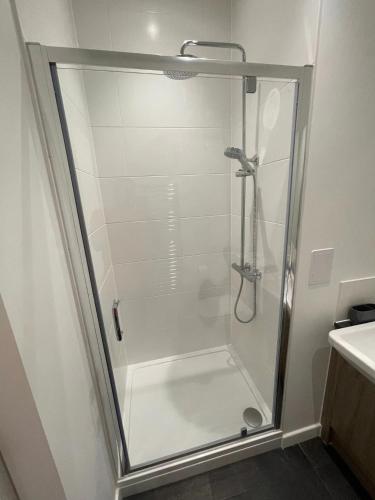 a shower with a glass door in a bathroom at 1 bed apartment in the heart of Staines town centre in Staines upon Thames