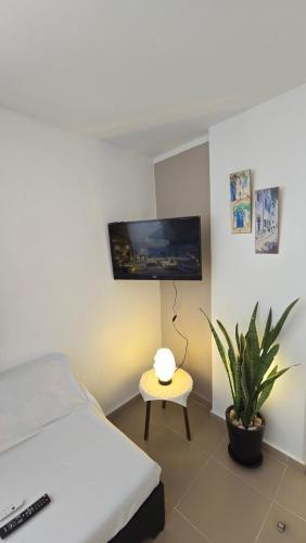 a bedroom with a bed and a table and a tv at Appartements de luxe près de la mer in Nabeul