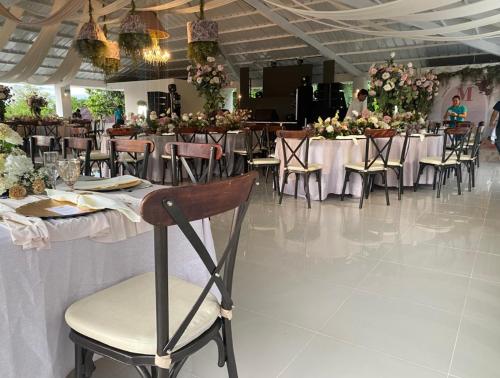 a dining room with tables and chairs and flowers at Hotel Centro vacacional El Cielo in Rivera
