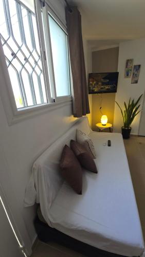 a bed in a room with a window at Appartements de luxe près de la mer in Nabeul