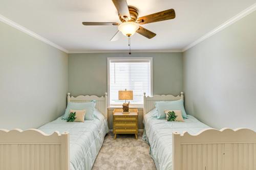 two beds in a bedroom with a ceiling fan at Lake Moultrie Access Moncks Corner Home with Dock in Moncks Corner
