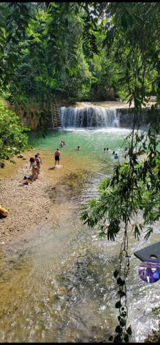 a group of people on a beach near a waterfall at Rancho Salto Yanigua in El Valle