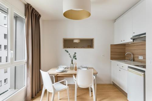a kitchen and dining room with a table and chairs at Appart hôtel Q7 Lodge Lyon 7 in Lyon
