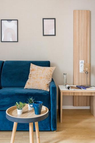 a living room with a blue couch and a table at Appart hôtel Q7 Lodge Lyon 7 in Lyon