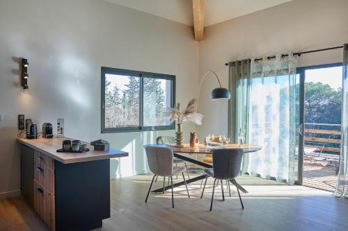 une cuisine avec une table et des chaises dans une pièce dans l'établissement Lodge et campagne, à Servian