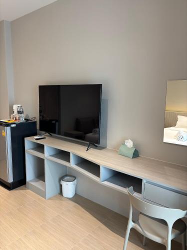 a desk with a television and a chair in a room at ซิตี้วรรณ ราชบุรี in Ratchaburi