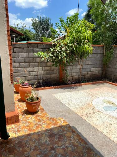 a patio with some plants and a brick wall at Liz Cozy Home in Nairobi