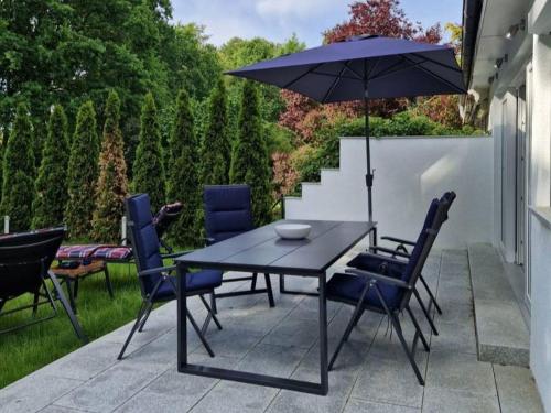 a table and chairs with an umbrella on a patio at Haus Wentowseeblick in Zehdenick
