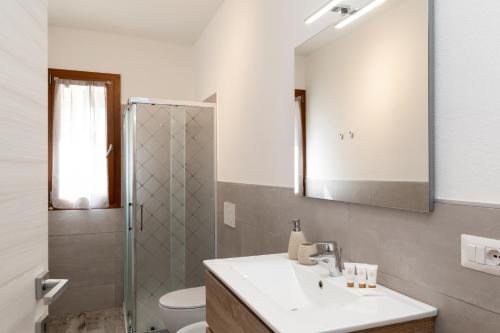 a bathroom with a sink and a toilet and a mirror at Zaira Home Free Wi-Fi 5 minuti dal Lago Liscia in Sant Antonio Di Gallura
