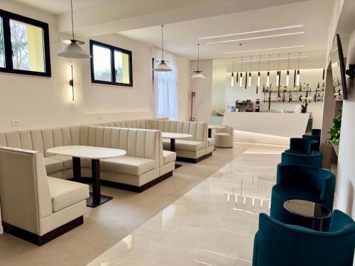 a waiting room with couches and a table and chairs at Le Naiadi Park Hotel Sul Lago in Bolsena