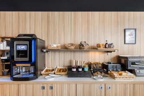 a bakery with bread and a coffee machine on a counter at Appart hôtel Q7 Lodge Lyon 7 in Lyon
