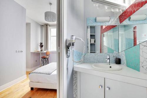 une salle de bain avec un lavabo et un miroir dans l'établissement Elegant 2 pièces moderne - rue du Colisée, à Paris