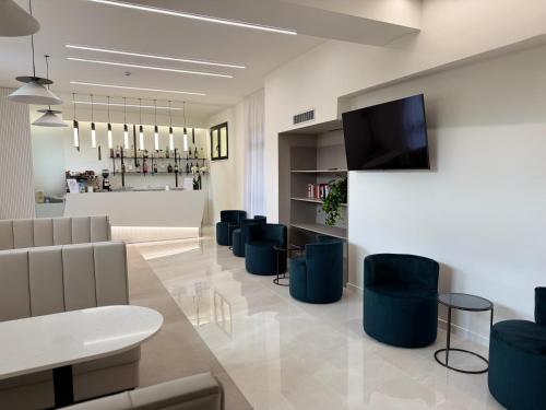 a lobby with a waiting room with chairs and a tv at Le Naiadi Park Hotel Sul Lago in Bolsena