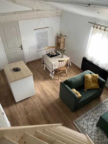 un salon avec un canapé vert et une table dans l'établissement Appartement LAISSAC - CENTRE VILLE - WIFI, à Montpellier