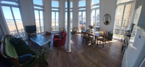 a living room with chairs and a table and windows at Imperial House "Serviced Apartments" in Margate