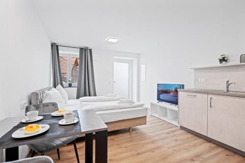 a white living room with a table and a couch at Stilvolles Apartment Bodensee A2 in Ravensburg
