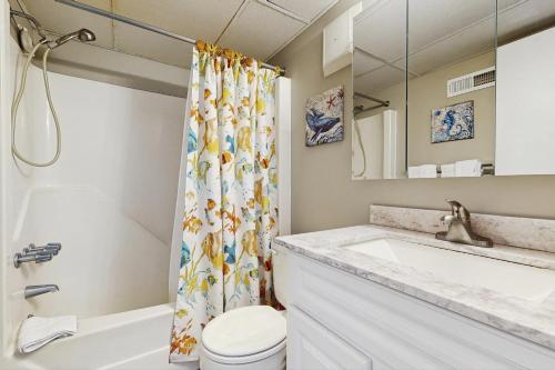 a bathroom with a sink toilet and a shower curtain at Breakaway East 512 in Ocean City