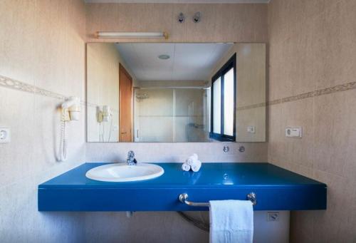 a bathroom with a blue sink and a mirror at FERGUS Club Pineda Splash in Pineda de Mar