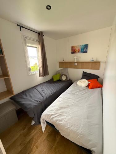 une petite chambre avec un lit et une fenêtre dans l'établissement MobilHome de la Coccinelle, à Gujan-Mestras