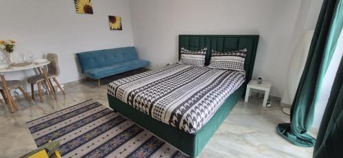a bedroom with a green bed and a blue couch at Marble Studio in Bucharest
