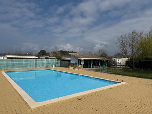 una grande piscina blu davanti a una casa di MobilHome de la Coccinelle a Gujan-Mestras
