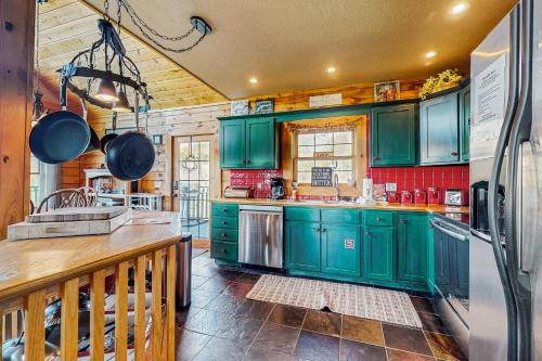 a kitchen with green cabinets and a refrigerator at Serenity Now in New Tazewell