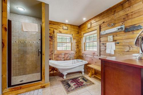 a bathroom with a bath tub and a sink at Serenity Now in New Tazewell
