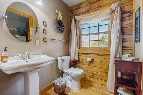 a bathroom with a toilet and a sink and a window at Serenity Now in New Tazewell