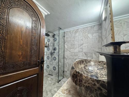 a bathroom with a large stone tub and a shower at RIAD ESMERALDA By Dar Ouezzani in Rabat