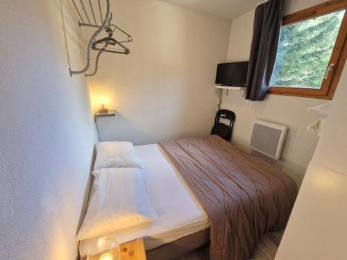 une petite pièce avec un lit et une fenêtre dans l'établissement Bel Appartement 4 Pièces pour 8, Près des Pistes à Valfréjus - FR-1-265-185, à Valfréjus