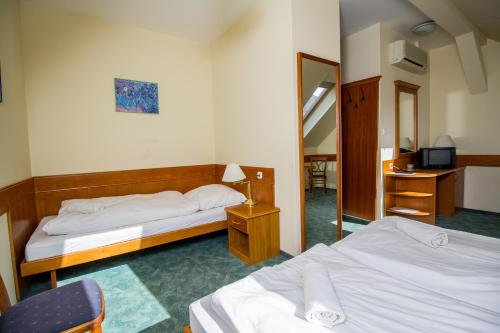 Hotel Corvinus tesisinde bir odada yatak veya yataklar