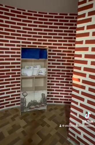 a brick wall with a shelf in a room at Hotel Centro vacacional El Cielo in Rivera