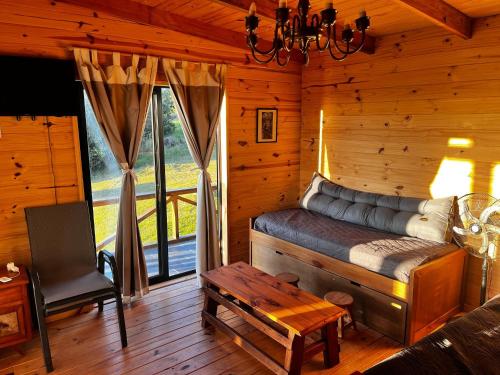 a room with a bed in a log cabin at Cabaña Los Ceibos. in Villa Serrana