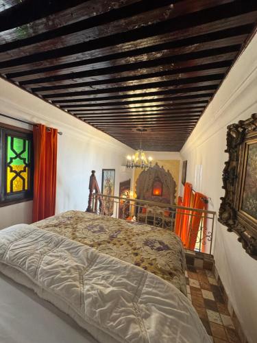 a bedroom with a large bed with a wooden ceiling at RIAD ESMERALDA By Dar Ouezzani in Rabat
