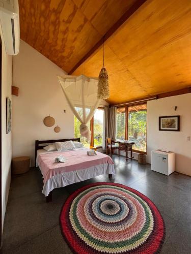 a bedroom with a bed and a large rug on the floor at Pousada Theodora in Macapá