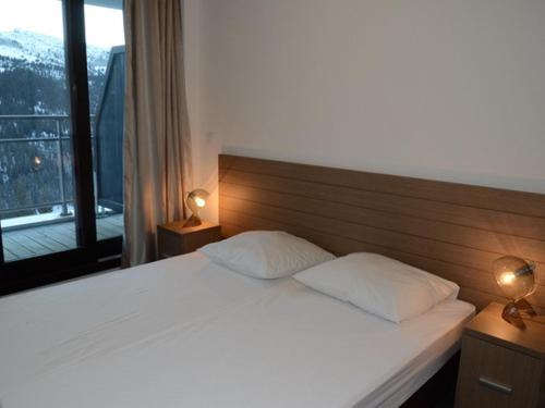 une chambre avec un lit blanc avec deux oreillers dans l'établissement Confortable 2 Pièces Sud avec Terrasse, Piscine, Spa et Parking - Flaine Forêt - FR-1-425-189, à Flaine