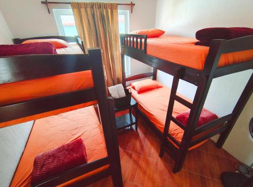a bedroom with two bunk beds with orange sheets at Gran Estancia in Esquipulas