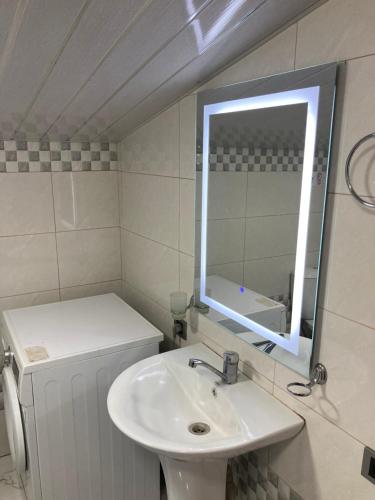 a white bathroom with a sink and a mirror at Armen’s Apartment in Yerevan